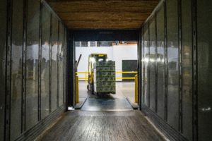 Warehouse loader unloading a load of boxes from a trailer