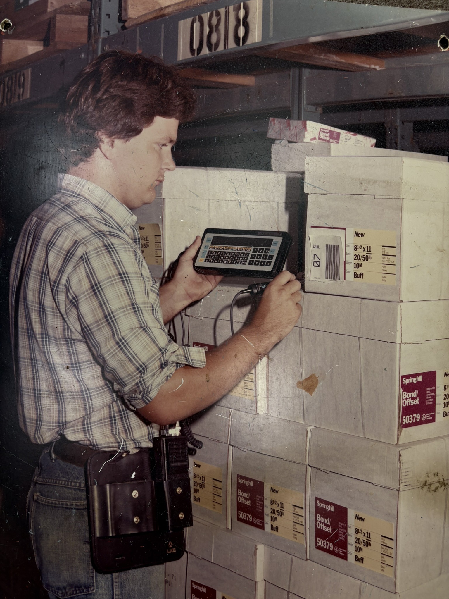 1995 -Gary Hardesty in a warehouse using an early-generation barcode wand scanner, showcasing the technology used before modern barcode scanners became standard.